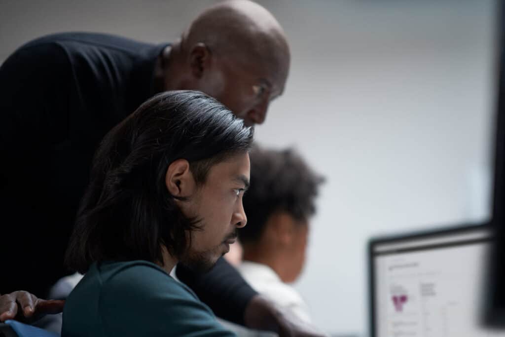 Three security experts looking at a computer.