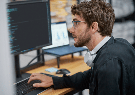 Photo of a male employee using a laptop in a small busines setting