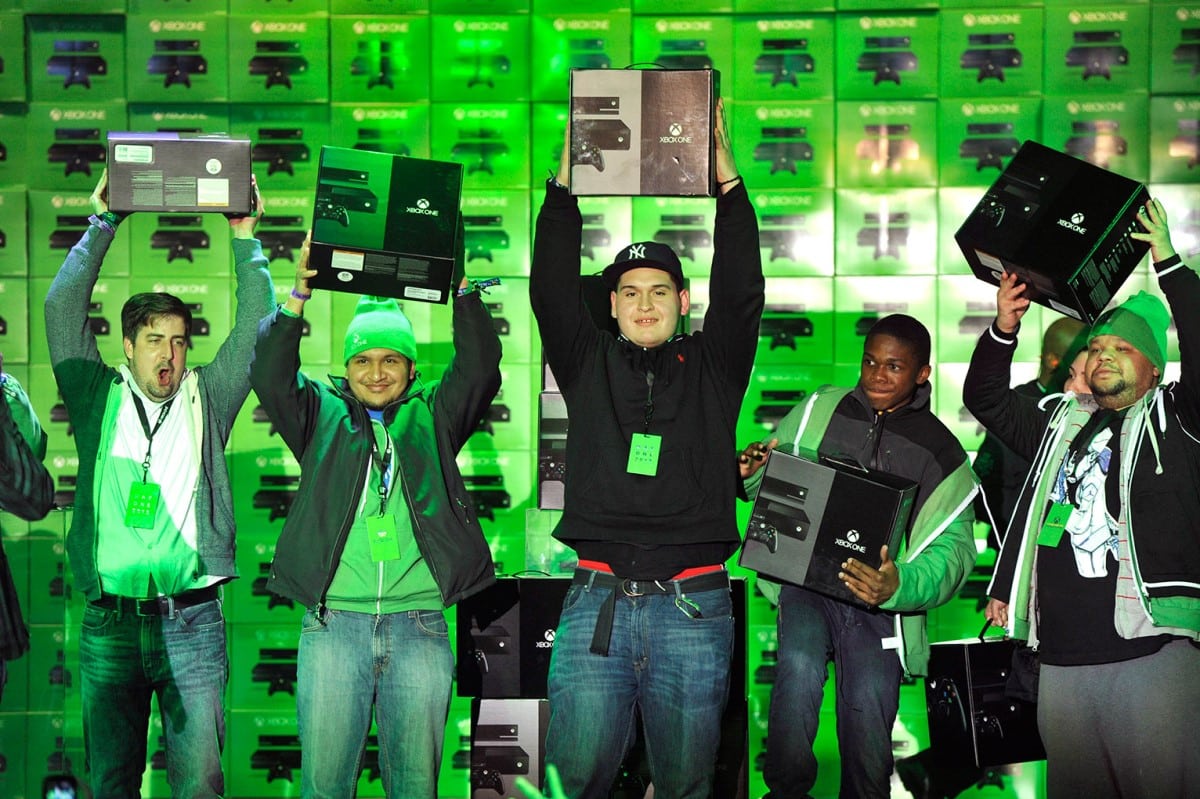 Happy Xbox One customers at a New York Launch event, holding their new Xbox products and smiling