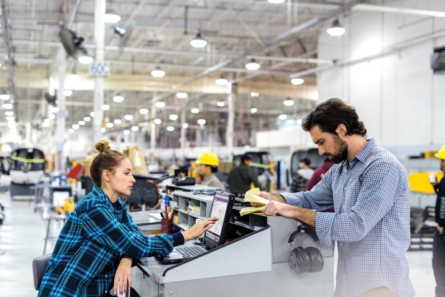 Manufacturing workers collaborating in factory setting