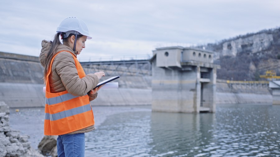 Female engineer working in hydroelectric dam. Ecology orientated. Renewable energy systems