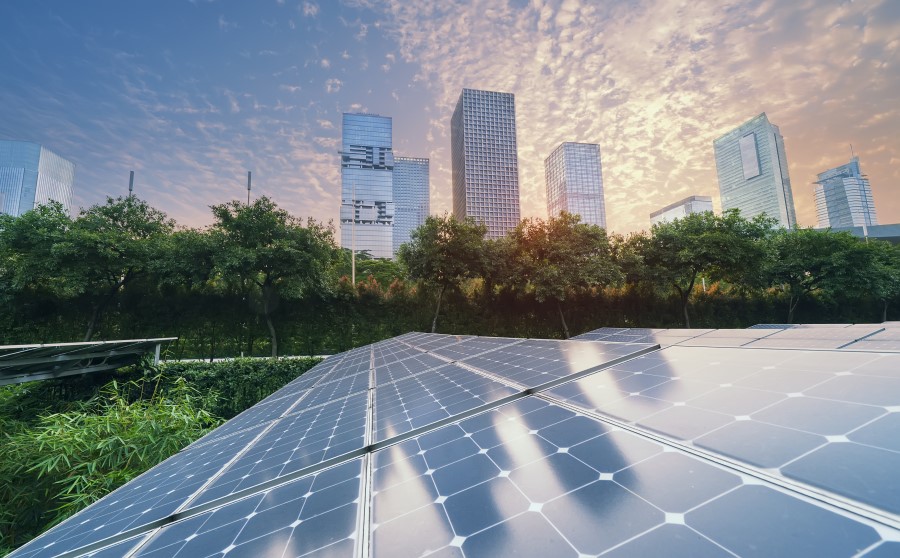 solar panels in front of city skyline