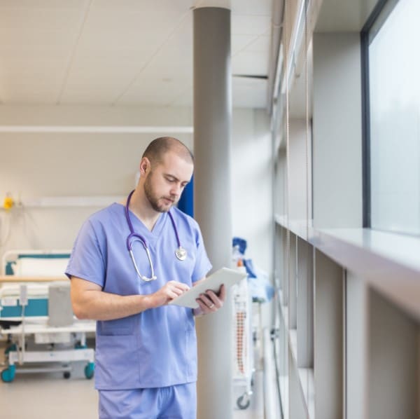 Doctor looking through notes on a tablet.