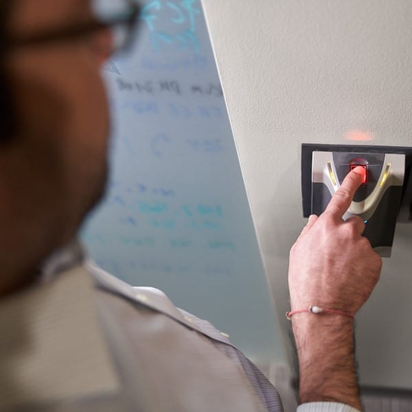 A person placing their finger on a fingerprint reader.