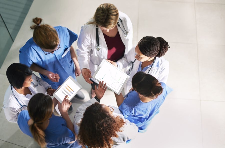High angle shot of a group of medical practitioners analyzing data in a hospital.