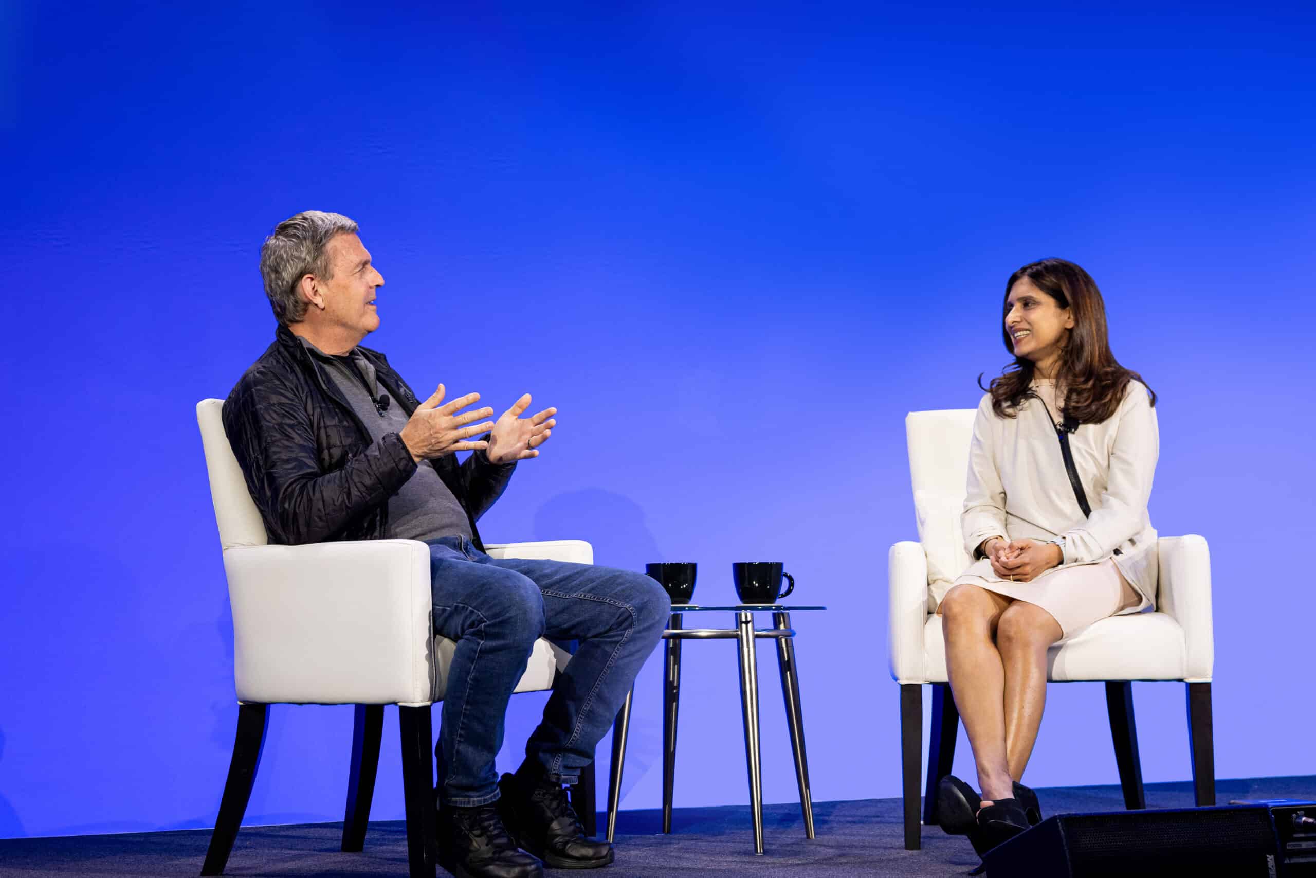 Vasu Jakkal and Charlie Bell discussing with one another on stage